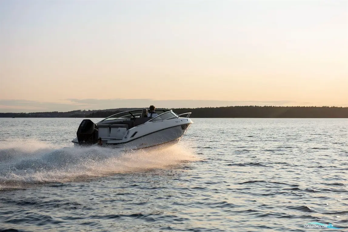 A speedboat splashes through water at sunset, with two people enjoying the ride against a serene lake backdrop.